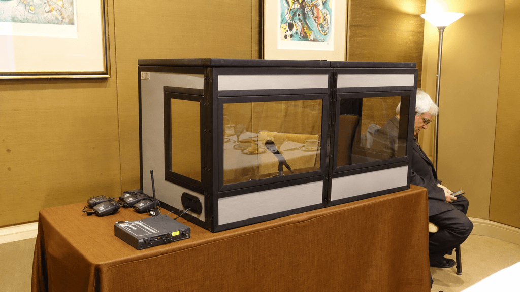 Tabletop interpreting booth set up on a table with the console and headsets in front