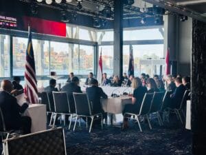 International delegates seated around the conference table at Pier One Sydney with national flags