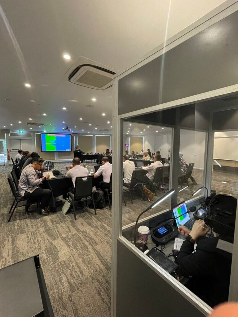 Full soundproof interpreting booth beside the delegation in session, Canberra